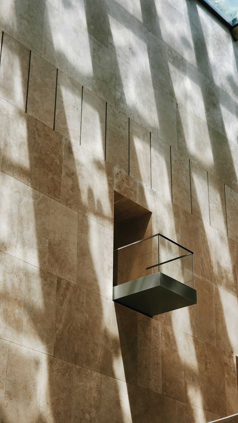 Geometric modern architecture in warm stone with precise light and shadow